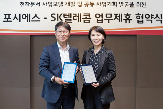 SK텔레콤는 전자문서 소프트웨어 개발사 포시에스와 전자문서 사업모델 개발 및 사업기회 발굴을 위한 업무협약(MOU)을 체결했다고 28일 밝혔다. 최은식 SK텔레콤 비즈마케팅본부장(왼쪽)이 박미경 포시에스 대표와 협약을 맺고 기념촬영을 하고 있다. <SK텔레콤 제공>